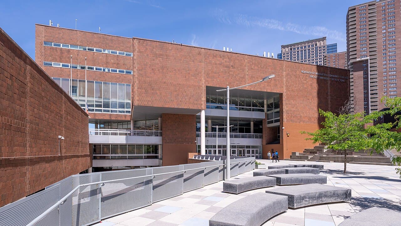 The brick main building of the Borough of Manhattan Community College in Tribeca, with stone benches on its plaza