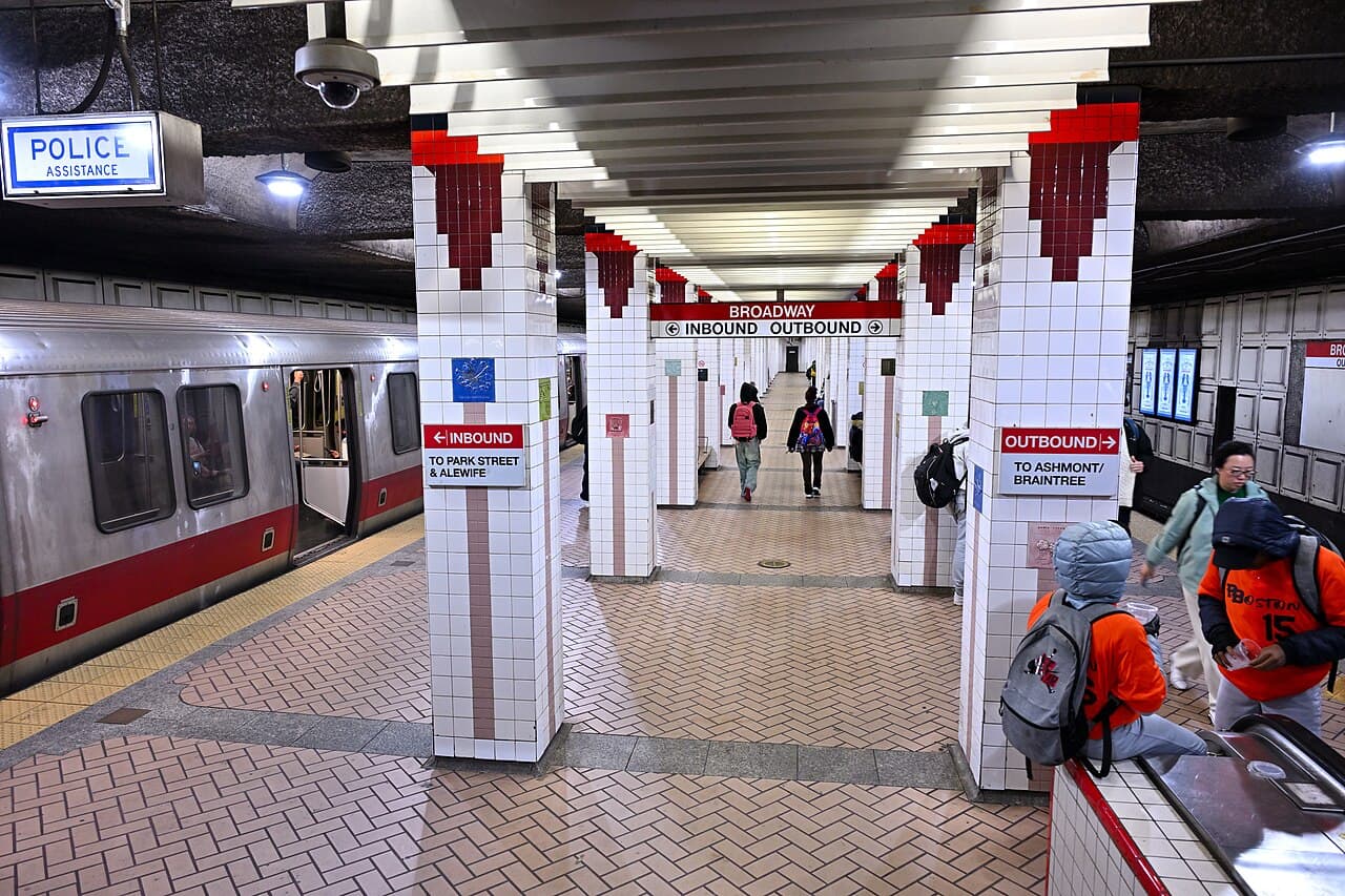 The Red Line platform at Broadway station in South Boston, with a train at the left and signs to Park Street and Ashmont or Braintree