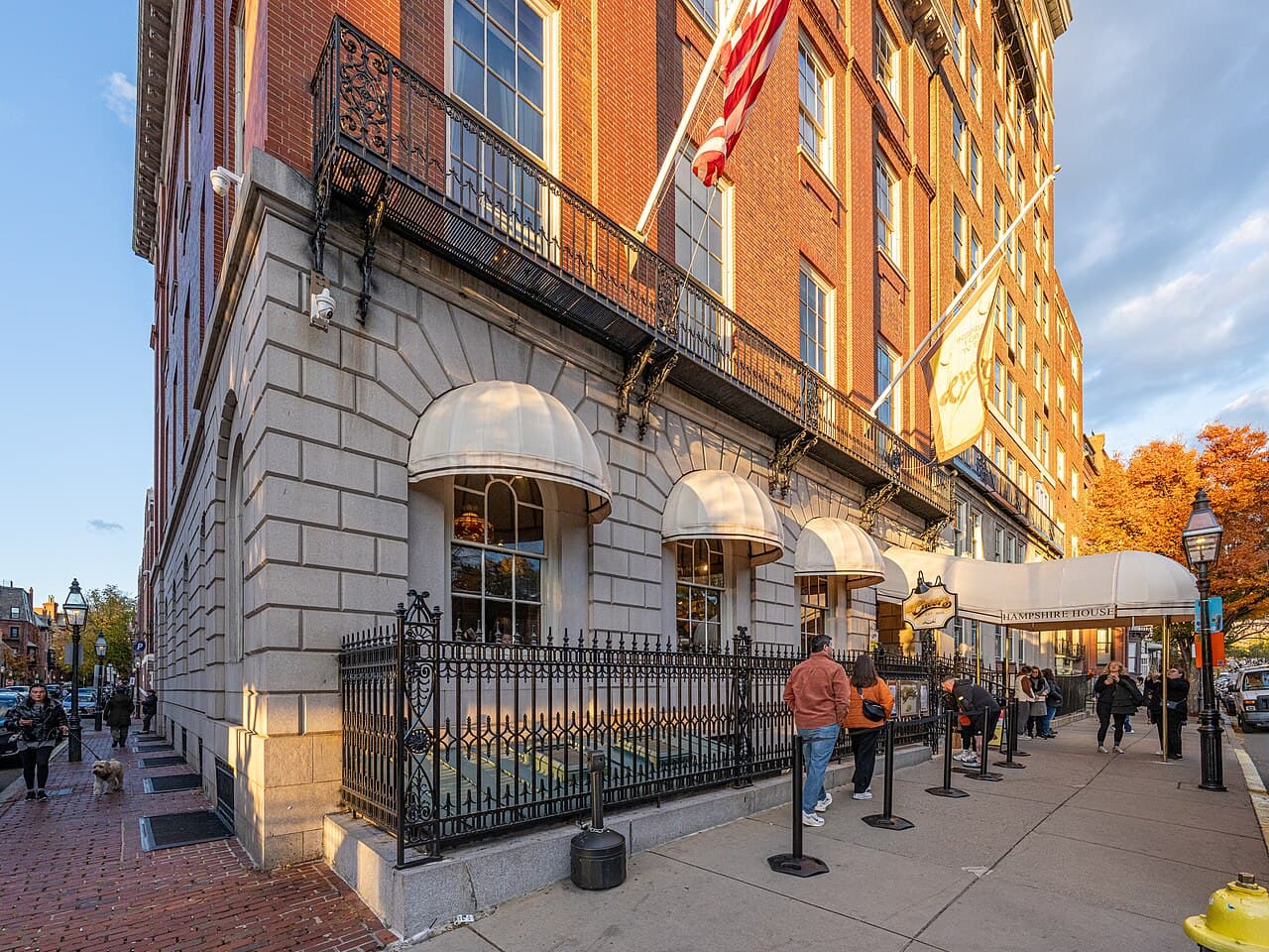 The brick and granite front of Hampshire House on Beacon Street in Boston, with white awnings and a canopy marked Hampshire House