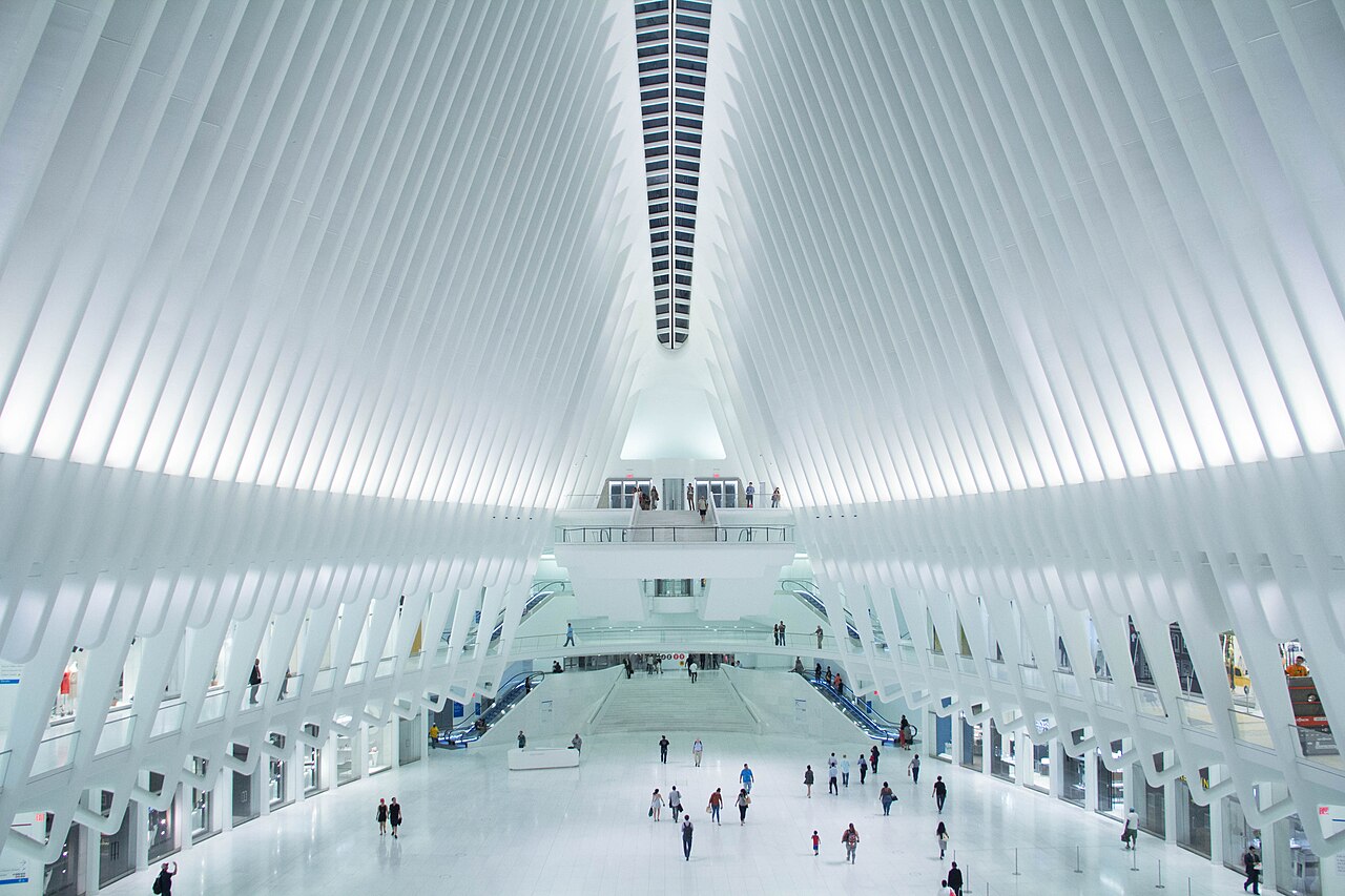 The white ribbed hall of the Oculus at the World Trade Center, with people crossing its floor