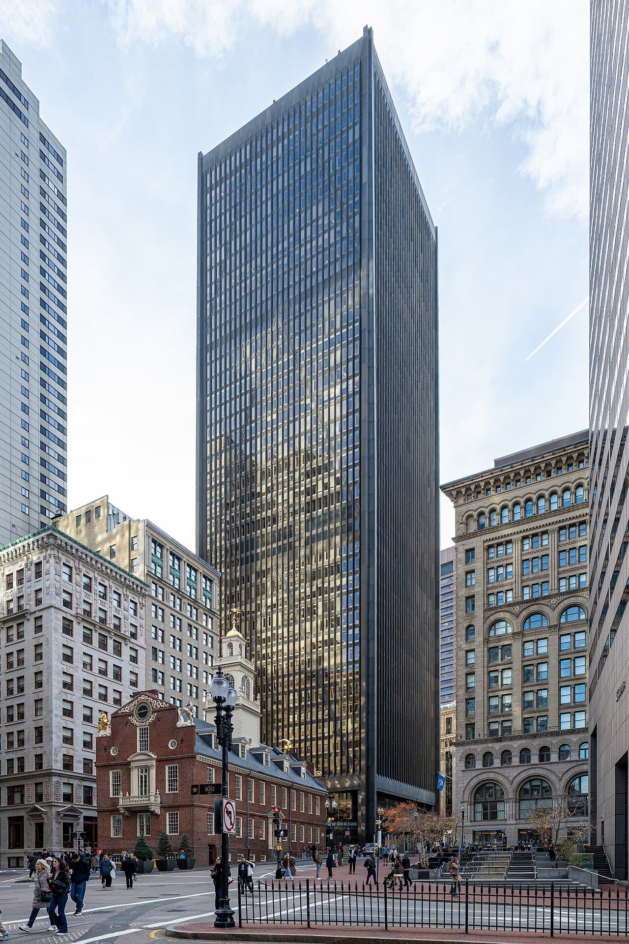 The dark glass tower of One Boston Place rising behind the red brick Old State House on Washington Street in downtown Boston