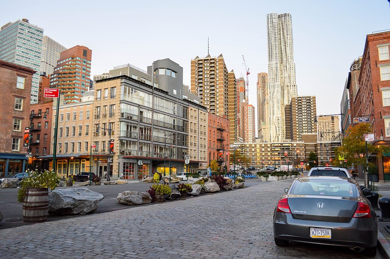 The cobbled street at Peck Slip in the South Street Seaport, with 8 Spruce Street rising behind it