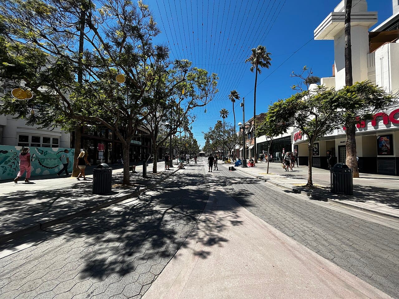 The Third Street Promenade in Santa Monica on a sunny day, with trees, palms and shops along the walkway