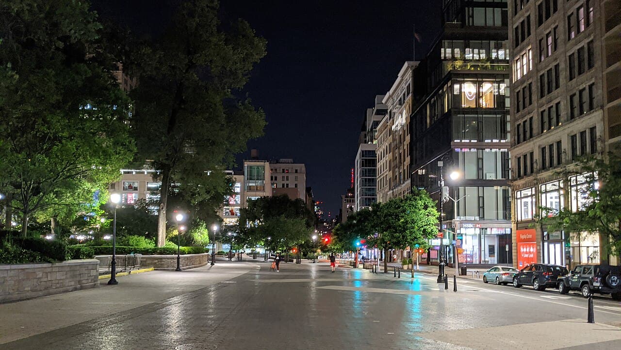 The plaza at Union Square at night, with trees and lit storefronts along the street