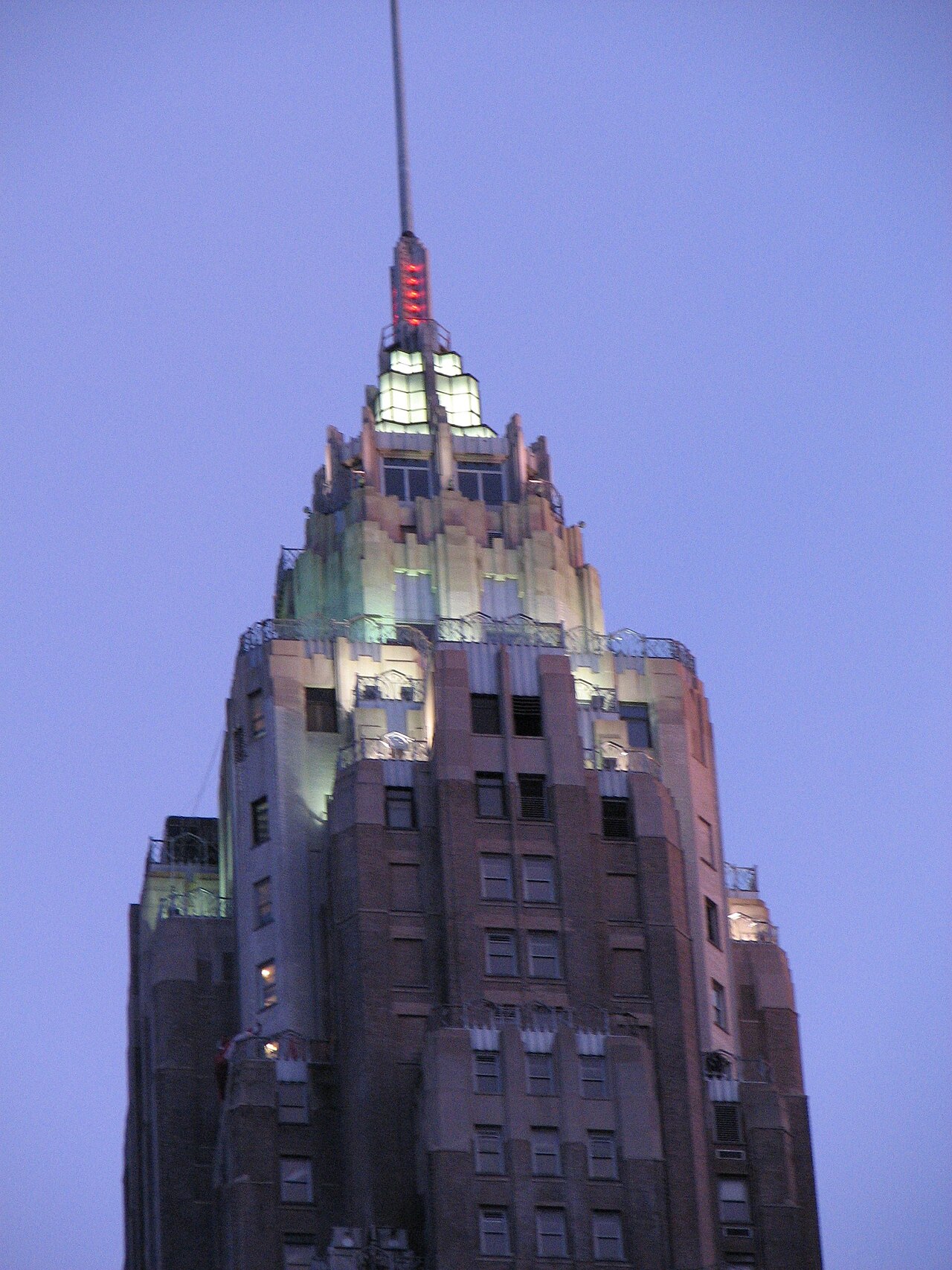 The lit crown and spire of 70 Pine Street against a dusk sky in the Financial District