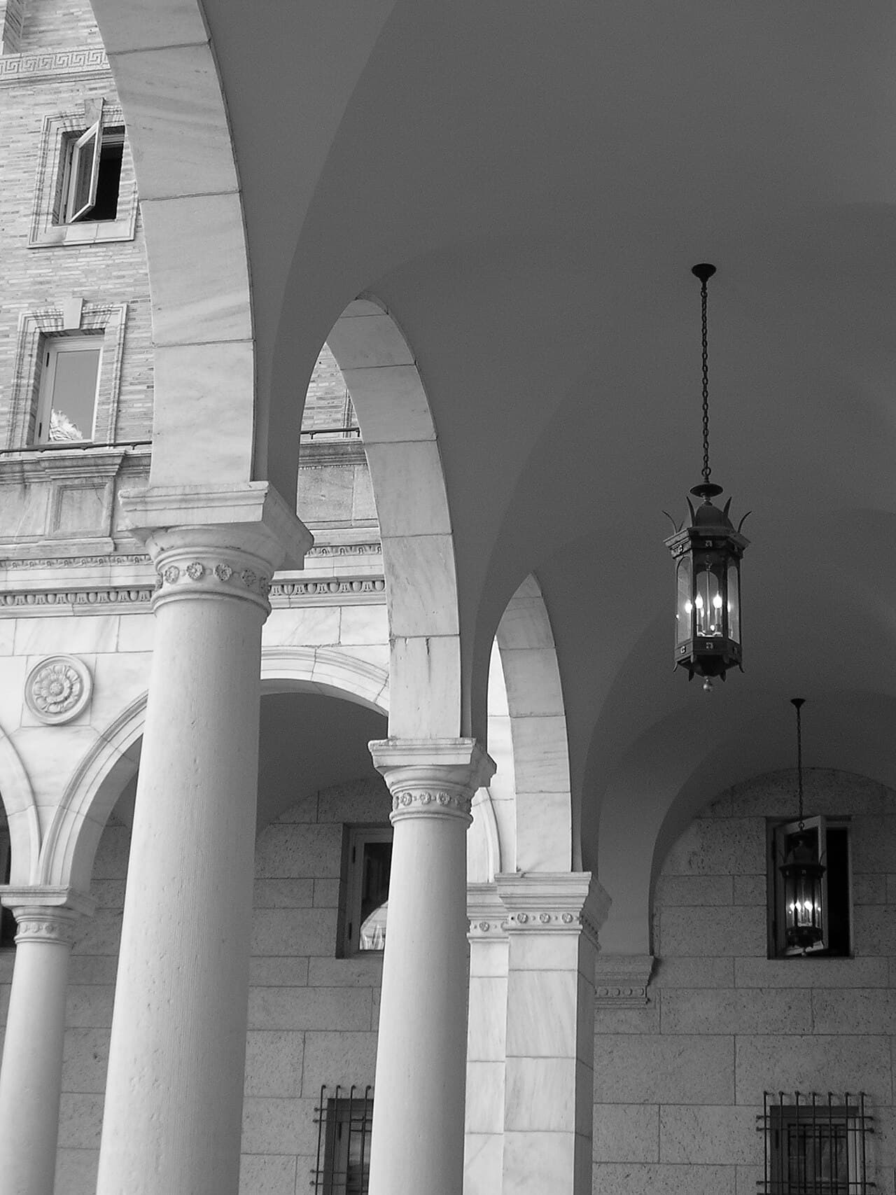 Marble columns, arches and hanging lanterns along the courtyard arcade of the Boston Public Library, a place to have a baby shower over afternoon tea