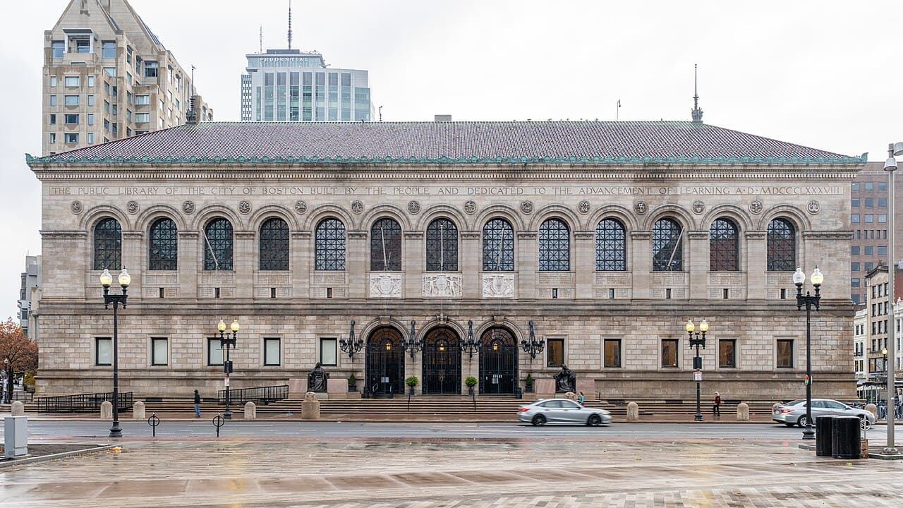 The granite front of the Boston Public Library's McKim Building on Copley Square, with arched windows and lamps by the entrance steps
