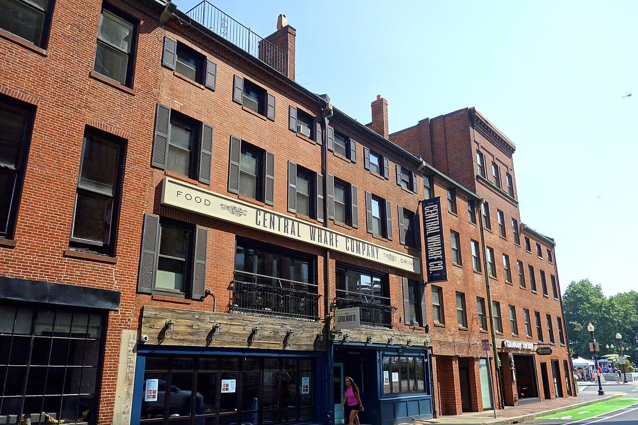 The brick front of Central Wharf Company at 160 Milk Street in Boston, a holiday party venue with its name on a long sign above the windows