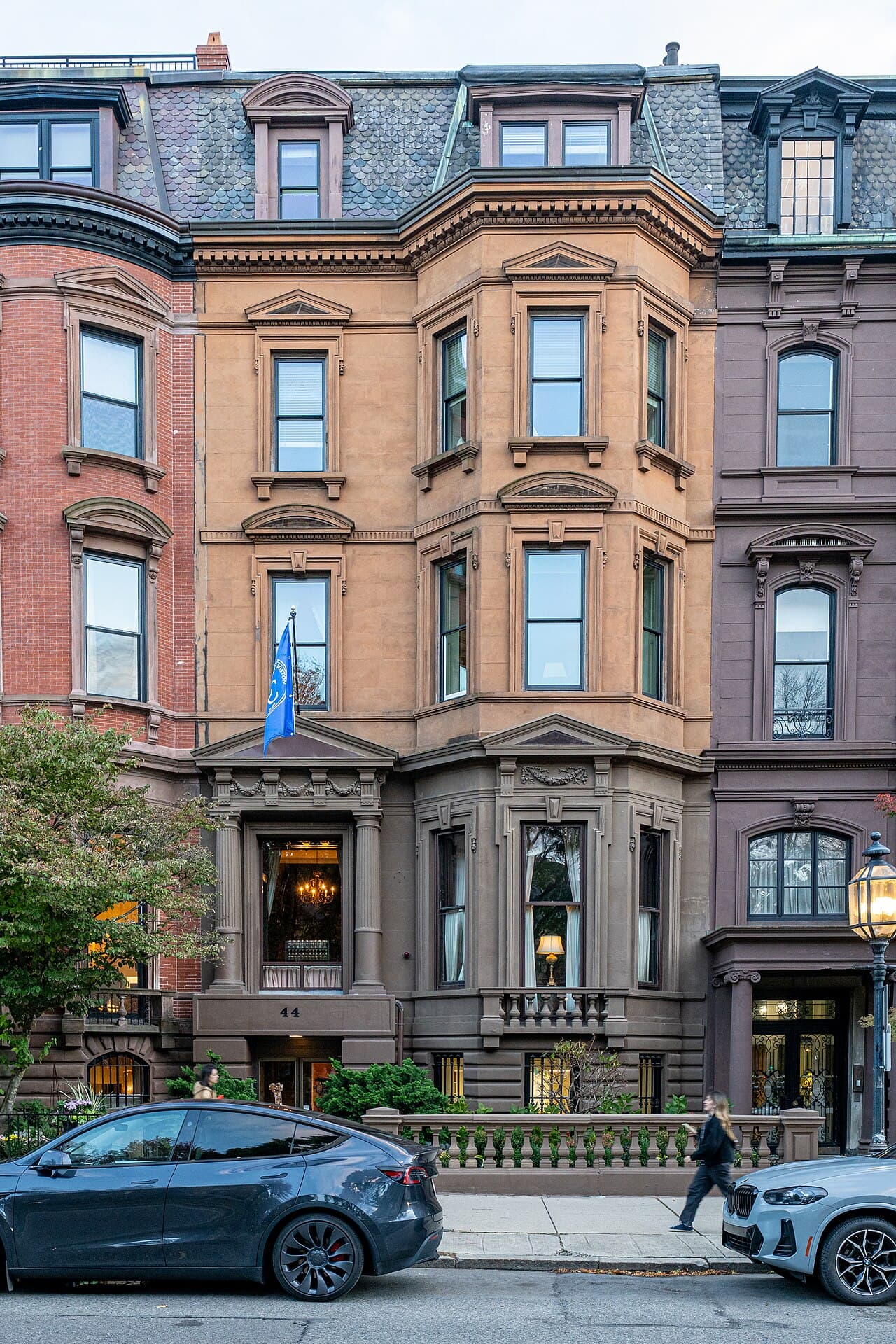 The brownstone front of the College Club of Boston at 44 Commonwealth Avenue in Back Bay, with a blue flag over the door