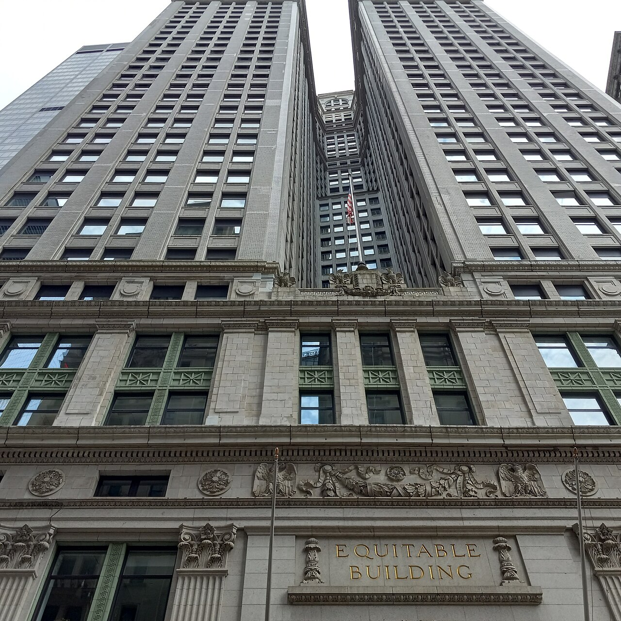 The Equitable Building's name above its entrance at 120 Broadway, with its two towers rising behind