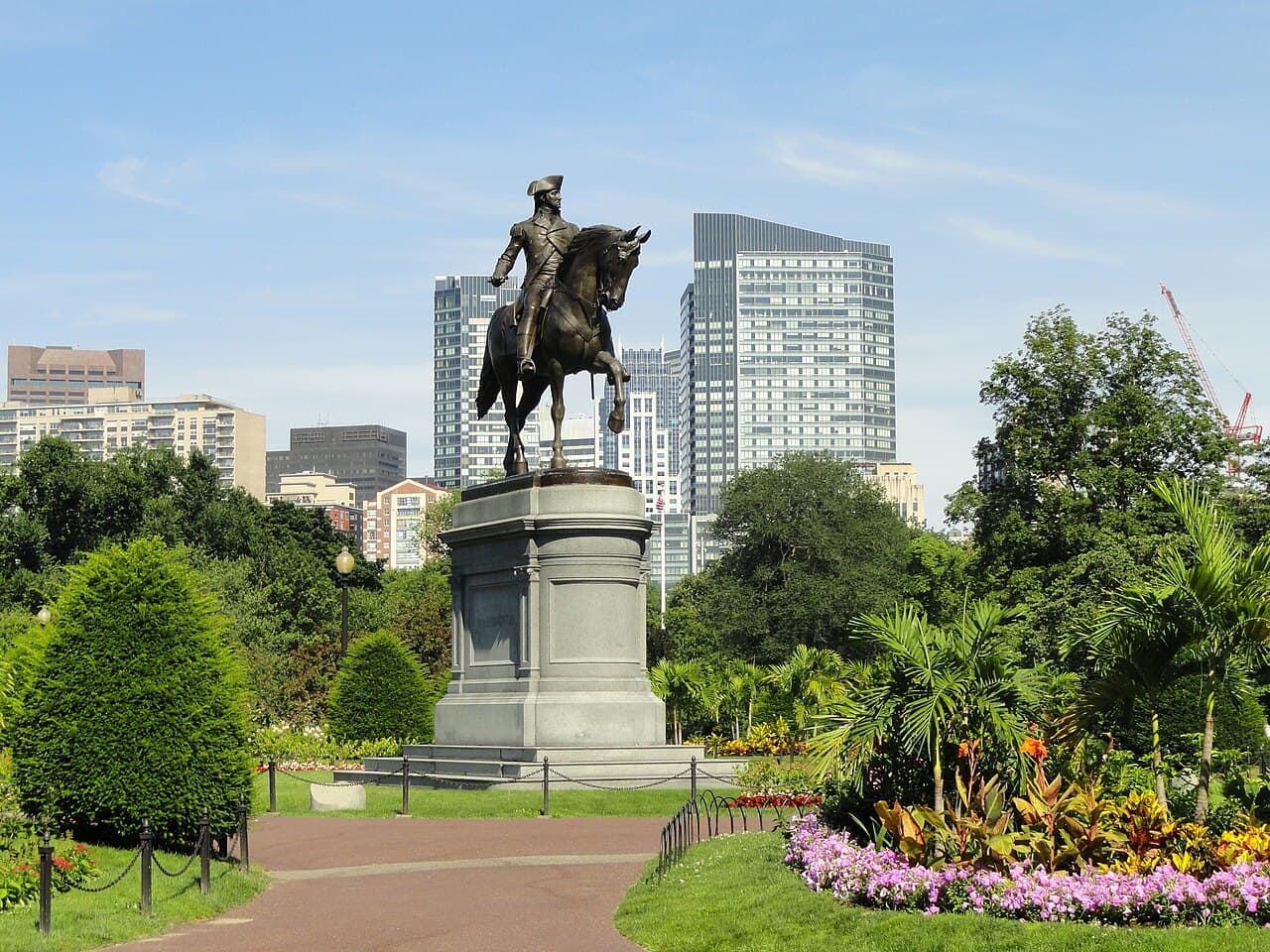 The George Washington statue on horseback in the Boston Public Garden, with flower beds and a brick path in front