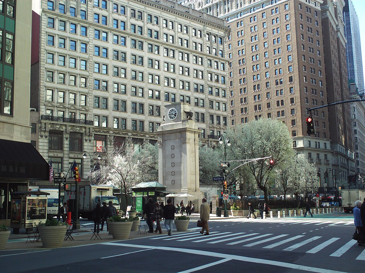 Herald Square's plaza and memorial clock in Midtown Manhattan, with office towers behind it
