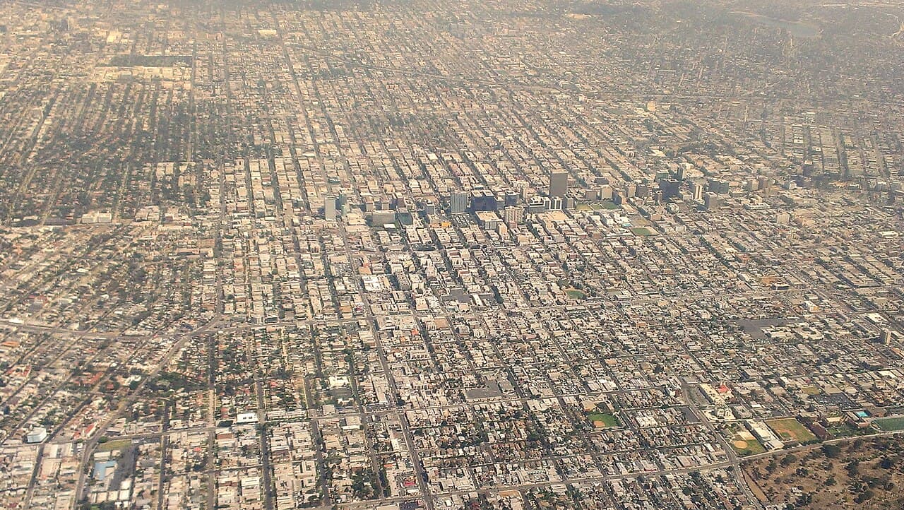 Aerial view of Koreatown in Los Angeles from the south, with a row of tall buildings across the middle of the street grid