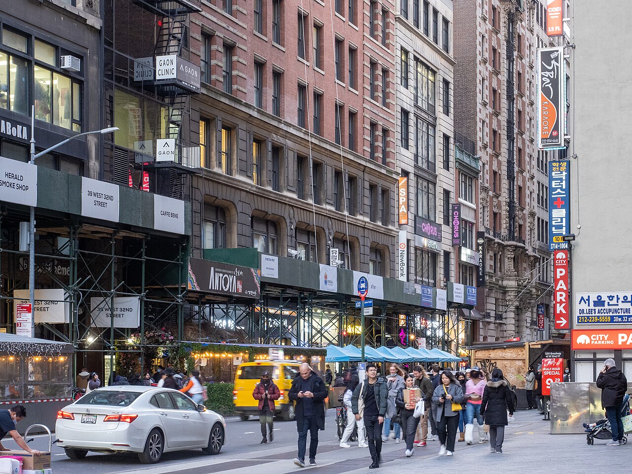 Shop signs and people walking on West 32nd Street in Koreatown, Manhattan