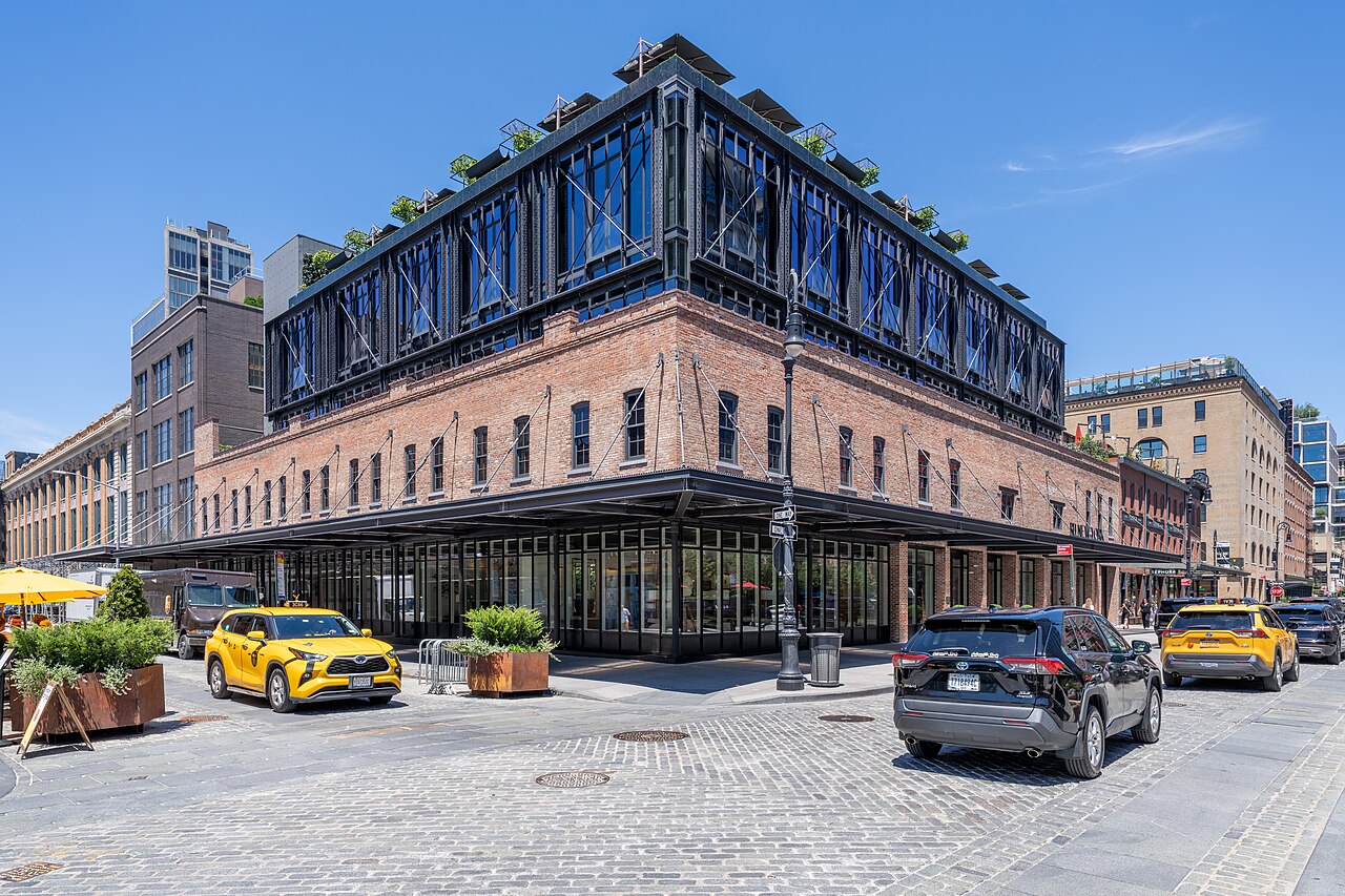 RH New York's brick building in the Meatpacking District, with a glass top floor and plants along its rooftop