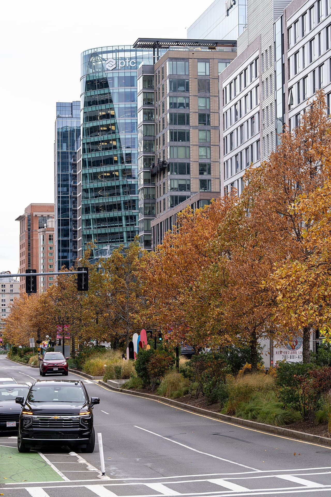 Seaport Boulevard in Boston with orange autumn trees along the median and glass office towers behind them